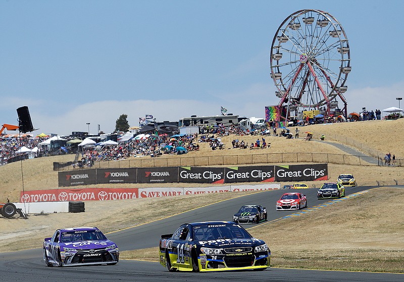 Tony Stewart (14) leads Denny Hamlin, left, race during the NASCAR Sprint Cup Series auto race Sunday, June 26, 2016, in Sonoma, Calif. Stewart won the race, Hamlin finished in second place. 