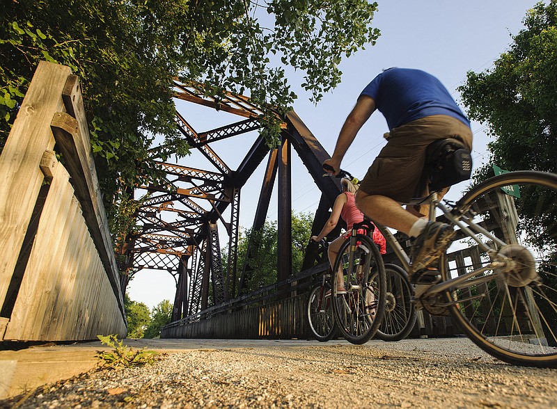 In this June 2016 photo, Katy Trail bicyclists cross over the Turkey Creek bridge as they make their way east toward the Katy Trailhead in North Jefferson City.