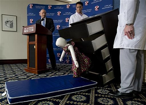 Consumer Product Safety Commission (CPSC) Chairman Elliot Kaye, left, watches a demonstration of how an Ikea dresser can tip and fall on a child during a news conference at the National Press Club in Washington, Tuesday, June 28, 2016. Ikea is recalling 29 million chests and dressers after six children were killed when the furniture toppled over and fell on them.