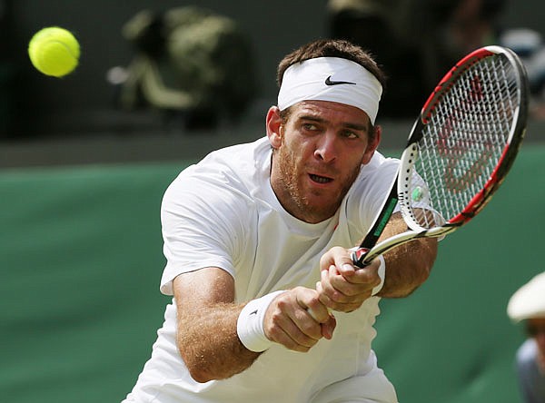 In this July 5, 2013, file photo, Juan Martin del Potro returns the ball to Novak Djokovic during their singles semifinal match at the All England Lawn Championships in London.