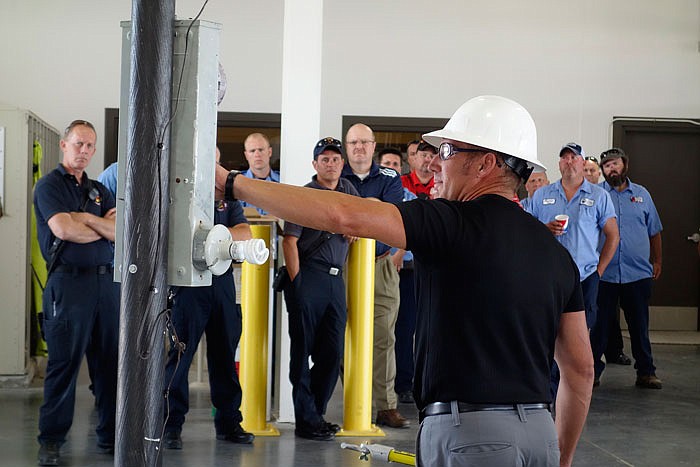 Clint Smith, manager of administration for Callaway Electric Cooperative, demonstrates safety techniques to a group of firefighters, police officers, EMTs, construction workers and municipal workers on Wednesday.