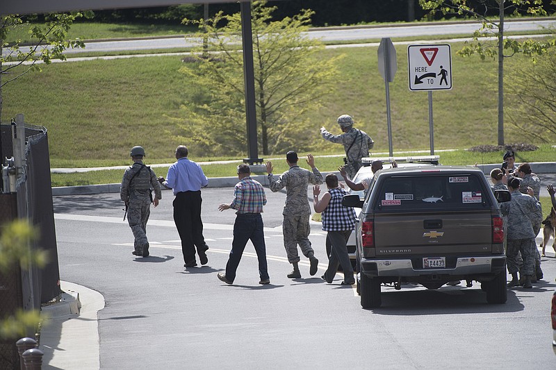People with arms raised people are lead out of the Malcolm Grow Medical facility on Andrews AFB in Morningside, Md., when the base was placed on lockdown Thursday, June 30, 2016, after an active shooter was reported. Officials say reports of an active shooter at the military post stemmed from someone who made a distress call Thursday after seeing security forces doing a routine inspection.