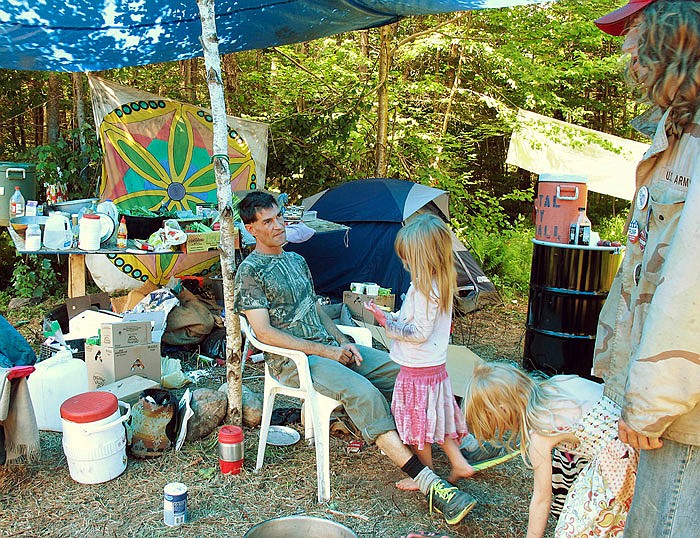 Members of the Rainbow Family of Living Light gather under a tarp at a gathering  in Mount Tabor, Vermont. People from across the country are flocking to the Green Mountain National Forest for the annual event.