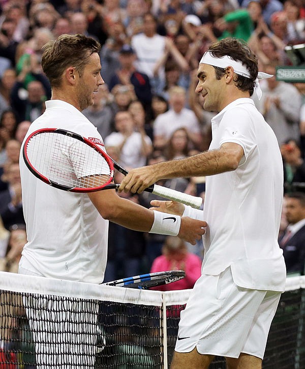 Roger Federer (right) shakes hands with Marcus Willis after beating him in their men's singles match Wednesday at Wimbledon in London.