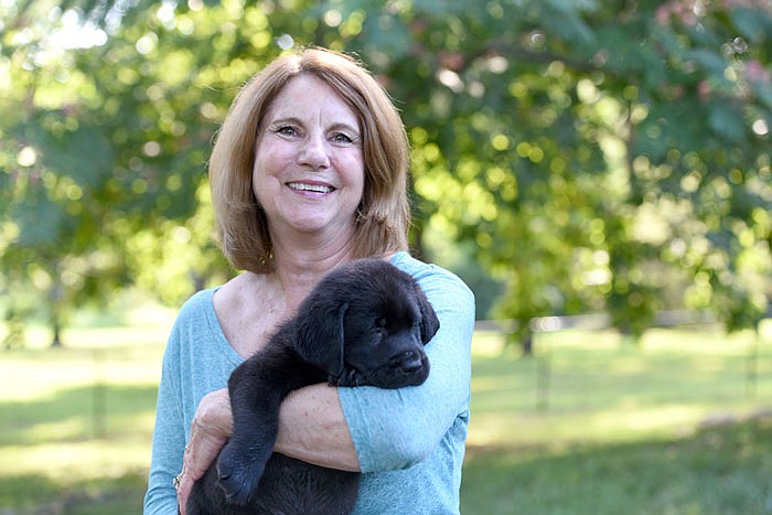 Kathy Peerson holds Zonta, the puppy named after the social services Zonta program, in her backyard. Peerson sought out programs where she could breed dogs to eventually become service animals.
