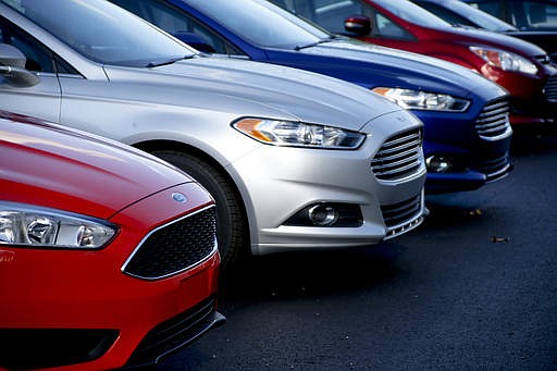 In this Thursday, Nov. 19, 2015, file photo, a row of new Ford Fusions are for sale on the lot at Butler County Ford in Butler, Pa.