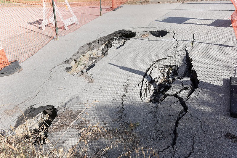 A sinkhole sits on Forest Hill Avenue and Forest Drive in Jefferson City. The city marked off the hole with orange fencing last summer, and the hole has yet to be fixed.