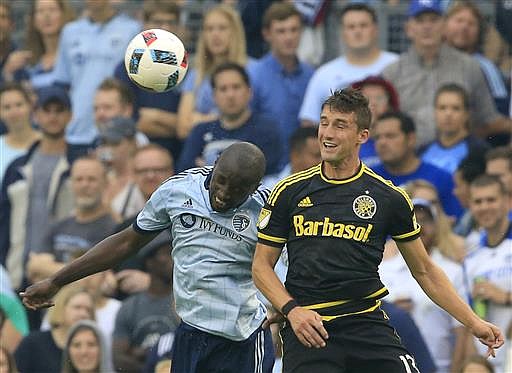 Sporting Kansas City midfielder Lawrence Olum, left, and Columbus Crew midfielder Ethan Finlay (13) head the ball during the first half of an MLS soccer match in Kansas City, Kan., Sunday, July 3, 2016. 