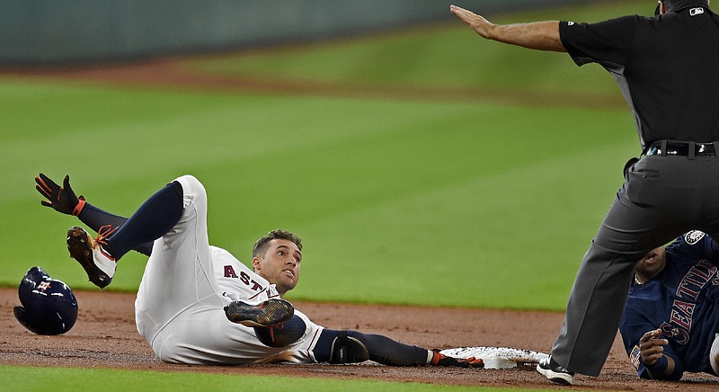 Houston Astros' George Springer looks up at second base umpire Brian Knight after sliding into second for a double during the first inning against the Seattle Mariners on Monday in Houston.