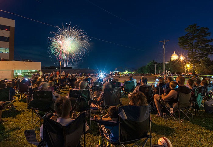 Revelers fill the Jefferson City Fire Department Station 1 lawn as colorful fireworks light the sky during the Salute to America "Red, White & Boom" fireworks display on Monday evening, July 4, 2017.