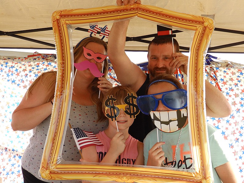 Kimberly and Wesley Satterfield and their son and daughter, Kelsey and Ryan, have fun playing with the props and posing for the camera at the photo booth in DeKalb, Texas. 
