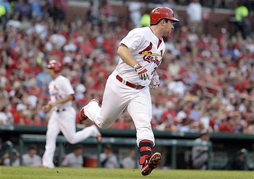 St. Louis Cardinals' Jedd Gyorko, right, runs to first on a single as teammate Stephen Piscotty comes in to score during the second inning of a baseball game against the Pittsburgh Pirates on Tuesday, July 5, 2016, in St. Louis. 