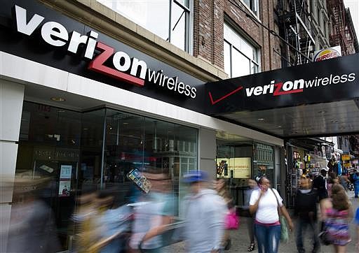  In this June 6, 2013, file photo, pedestrians pass a Verizon Wireless store on Canal Street in New York. 