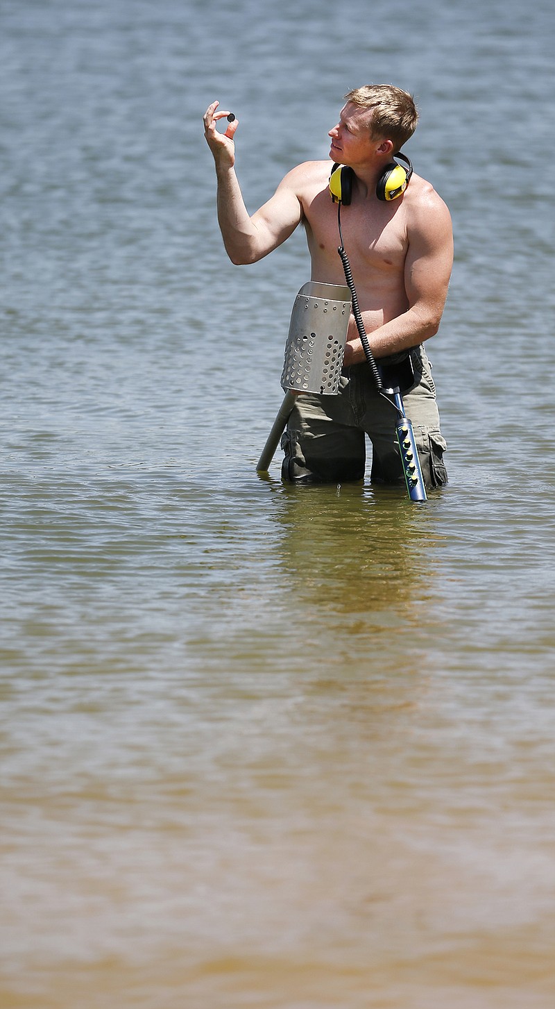 Buffalo Springs resident, Kelly Hildebrandt looks at a quarter he just found. He was using a metal detector to look for metal objects in Buffalo Springs Lake, Tuesday, July 5, 2016 in Buffalo Springs, Texas. Hildebrandt said that the most interesting thing he has found was a 1942 Lady Liberty silver dollar while in Kauai, Hawaii. Today he found two quarters and a pull tab. 