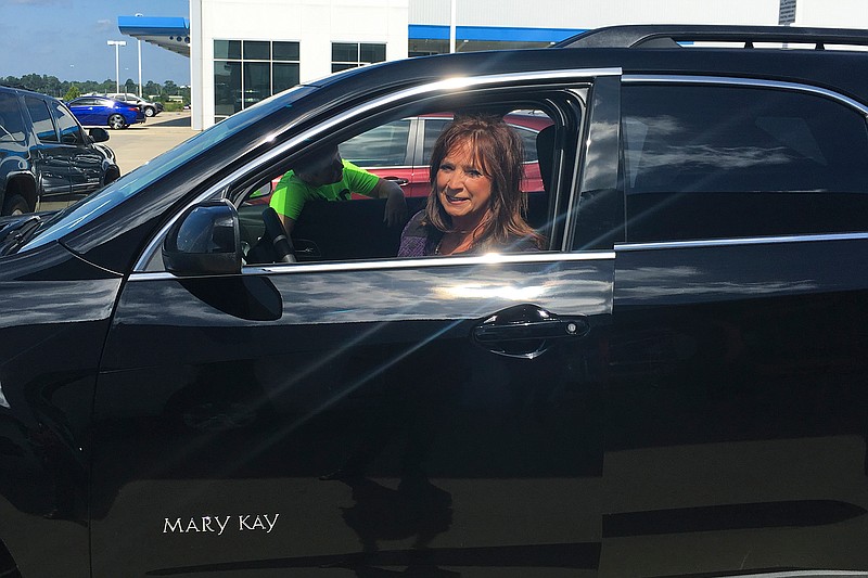 Valera Wilhite of Texarkana, Ark., inspects her new 2017 Chevrolet Equinox on Thursday morning, July 7, 2016  at Orr Chevrolet. Her grandson is in the background. Wilhite received the vehicle for meeting her Mary Kay sales quota for two years. This is the  15th vehicle she has received from Mary Kay in her 26 years with the cosmetics company.