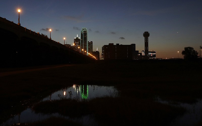 Reunion tower, right, stands with the lights out as the sun rises Friday, July 8, 2016, over downtown Dallas. Many Dallas businesses turned out their lights to honor the police killed and wounded in an attack Thursday evening.