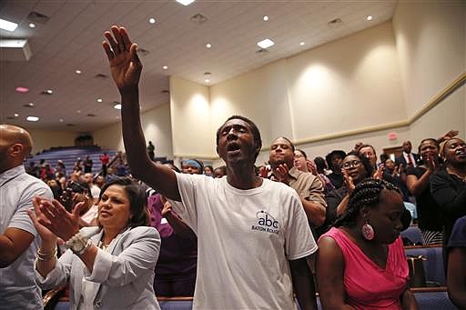 Members of the Living Faith Christian Center congregation sing a hymn at a prayer vigil for Alton Sterling, who was shot by Baton Rouge police in Baton Rouge, La., Thursday, July 7, 2016. Sterling, 37, was shot and killed outside the convenience store, where he was selling CDs.