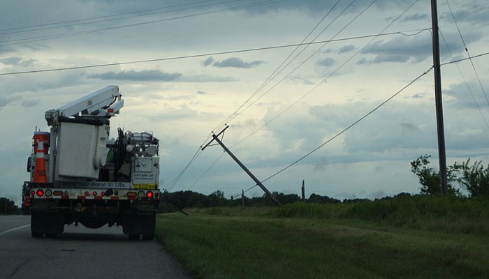 A work truck sits outside fallen power lines on U.S. 54 Thursday near Kingdom City.