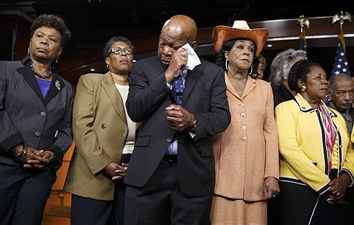 Civil rights leader Rep. John Lewis, D-Ga., center, wipes his eyes as members of the Congressional Black Caucus make emotional statements condemning the slayings of police officers in Dallas, and the fatal police shootings of black men in Louisiana and Minnesota earlier in the week, during a news conference on Capitol Hill in Washington, Friday, July 8, 2016. From left are: Rep. Barbara Lee, D-Calif., Rep. Marcia L. Fudge, D-Ohio, Rep. John Lewis, D-Ga., Rep. Frederica Wilson, D-Fla., and Rep. Sheila Jackson Lee, D-Texas.