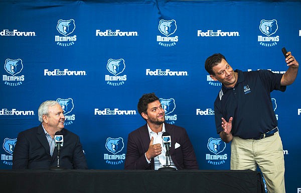 Grizzlies general manager Chris Wallace (left) watches new Grizzlies player Chandler Parsons (center) has his photo taken with Grizzlies TV sideline reporter Rob Fischer during a news conference Friday in Memphis, Tenn.