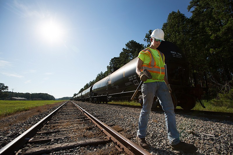 Jonathan Lindsey with Lonestar Railcar Storage walks June 29, 2016 to meet up with other crew members repairing a rail line.