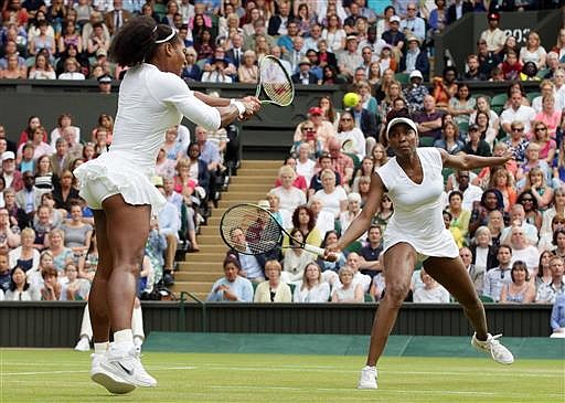 Serena Williams, left, and Venus Williams of the U.S return to Yaroslava Shvedova of Kazahkstan and Timea Babos of Hungary during the women's doubles final on day thirteen of the Wimbledon Tennis Championships in London, Saturday, July 9, 2016.
