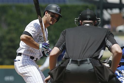 In this June 29, 2016, file photo, Colorado Rockies' Nolan Arenado, left, reacts as home plate umpire Nic Lentz, right, calls a strike on a pitch from Toronto Blue Jays starting pitcher Aaron Sanchez in the first inning of a baseball game in Denver. 