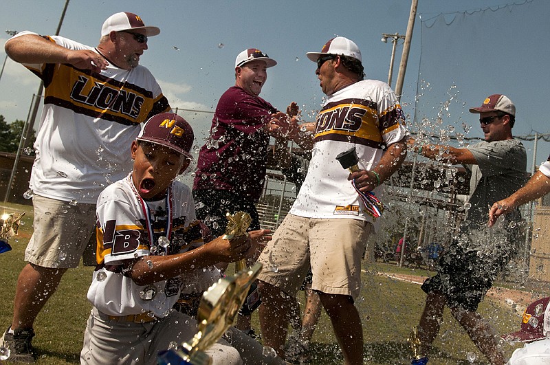 New Boston Lions assistant coaches Brandon Barrett, left, Jordan Harrison, bottom, and head coach Byron Henson, center, react to a cooler of water being dumped on them Monday after winning the Dixie 10-and-under Division II state championship against Daingerfield, 13-1, at Swanger Sportsplex in Texarkana, Texas.