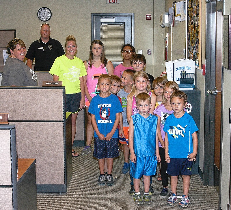 Shown in the California Police Department facility are, from left, Roberta Gunnerson - Little Pintos staff member, Sgt. Scott Harkins - California Police Department, Tabatha Oswald - Little Pintos owner and the young people from Little Pintos Preschool and Playhouse. The group visited the department Friday, July 8.