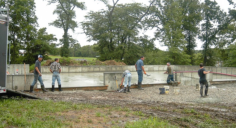 A crew from Brubaker Construction works on concrete finish work on a concrete floor at the new Mid-Mo Ambulance base as the Thursday storm nears its end. The new base is on Hartley St. on the south edge of California on south Highway 87. The crew began work before the storm hit and continued working throughout the rainstorm.