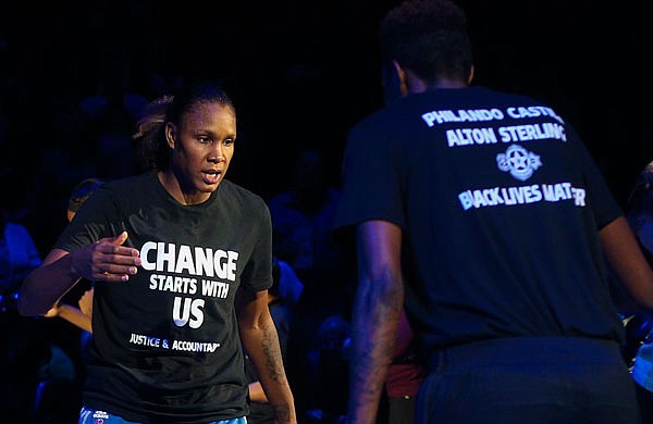 Lynx forward Rebekkah Brunson (left) is greeted by Lynx forward Natasha Howard while starting lineups are announced at the Target Center on Saturday. Lynx players did not wear T-shirts supporting the Black Lives Matter movement ahead of Tuesday's game in San Antonio after four off-duty police officers walked away from security jobs at a Lynx game during the weekend because of the T-shirts.