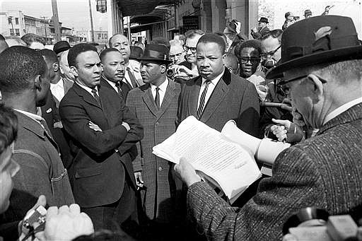 In this March 9, 1965 file photo, Andrew Young, from left, and Dr. Martin Luther King Jr., look on as a federal marshal reads a court order halting a planned voter registration protest march in Selma, Ala. The Georgia NAACP is criticizing civil rights icon Andrew Young for calling some demonstrators "unlovable little brats" in a speech to Atlanta officers, saying Young should instead join the protesters in demanding police reform. Young made the comments while meeting with Atlanta police officers at a police station over the weekend. He gave a morale-boosting talk to the officers and thanked them for their efforts during recent Atlanta demonstrations after black men were killed by officers in Louisiana and Minnesota.