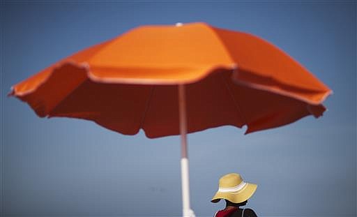 A woman sits next to an umbrella while looking out toward the ocean in Folly Beach, S.C. That sunscreen in your bag may not protect your skin as much as you think. Even after regulators updated standards for labeling sunscreen in 2012, tests have shown many provide far less protection than advertised. If you're going to be outside, experts recommend finding some shade and wear clothing that covers your arms and legs, and a broad-brimmed hat to protect your face, ears and neck.