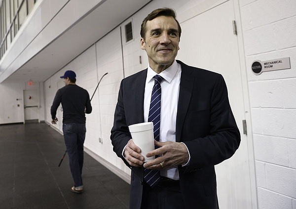 In this April 28, 2014, file photo, former Capitals general manager George McPhee stands after talking with Capitals player Troy Brouwer in Arlington, Va. McPhee has been hired as general manager of the NHL's expansion Las Vegas franchise.