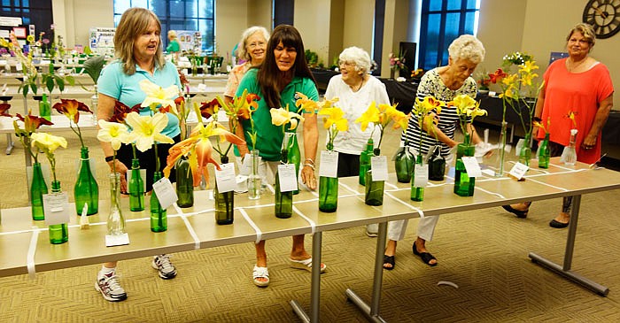 From left, Mary K. Day, Ann Wakeman, club President Diane Neterer, Joan Sampson, Becky Guerrant and Fran Leake prepare a table of lillies for the Fulton Garden Club Standard Flower Show.