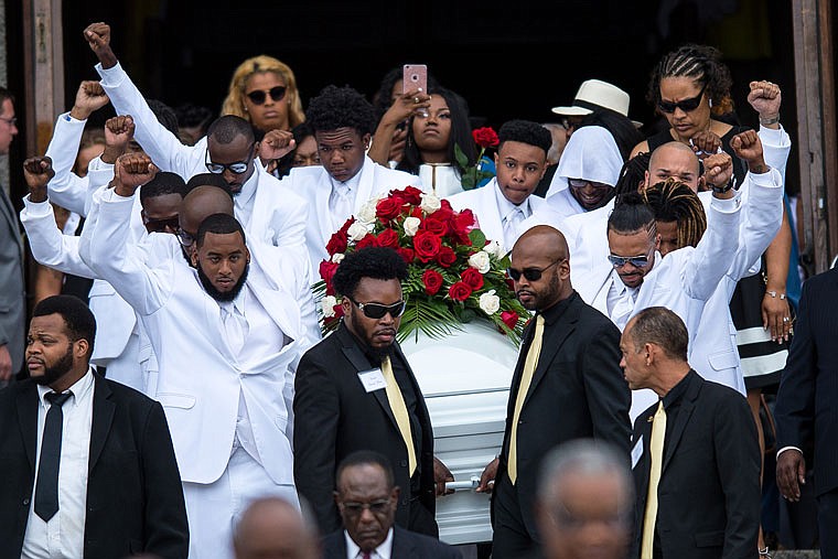 Pallbearers raise their fists into the air as they carry the casket of Philando Castile back to the horse drawn carriage following Castile's funeral service at the Cathedral of Saint Paul Thursday in St. Paul, Minnesota. Castile was killed by a police officer during a traffic stop last week. 