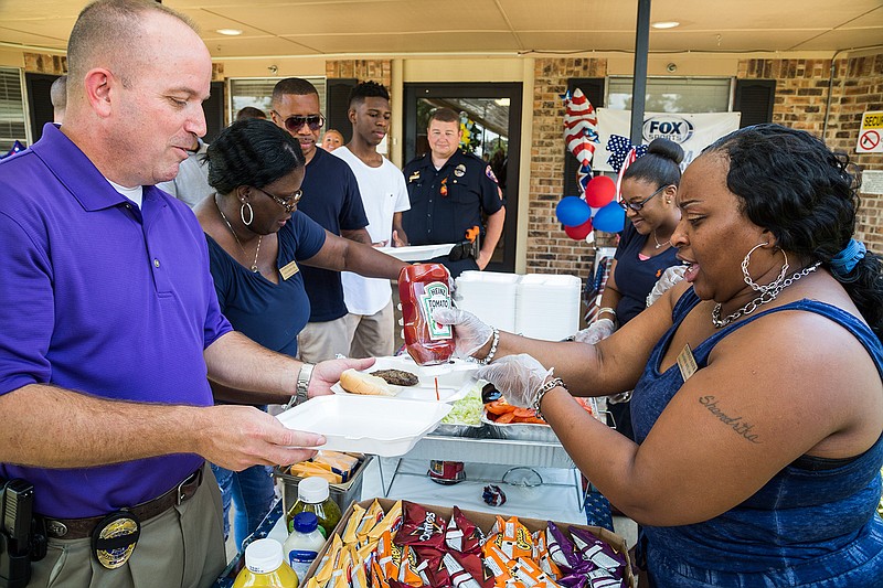 Texarkana, Texas, Police Lt. Shawn Fitzgerald receives ketchup from Shandrika Boyd on Friday, July 15, 2016 during a law enforcement appreciation lunch at Edgewood Manor. "I like to dip my burger in the ketchup," Fitzgerald said. 
