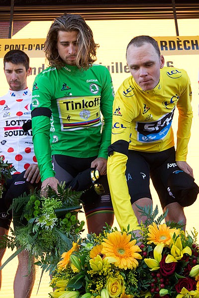 Peter Sagan, wearing the best sprinter's green jersey, and Chris Froome, wearing the overall leader's yellow jersey,  lay flowers after a moment of silence at the conclusion of Friday's stage in the Tour de France.