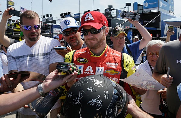 In this June 11 file photo, fans seek autographs from Dale Earnhardt Jr. before a practice session for the NASCAR Sprint Cup series at Michigan International Speedway in Brooklyn, Mich.