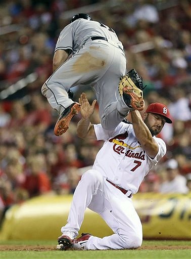 Miami Marlins' J.T. Realmuto, top, collides with St. Louis Cardinals first baseman Matt Holliday on a ground out during the fifth inning of a baseball game, Friday, July 15, 2016, at Busch Stadium in St. Louis.