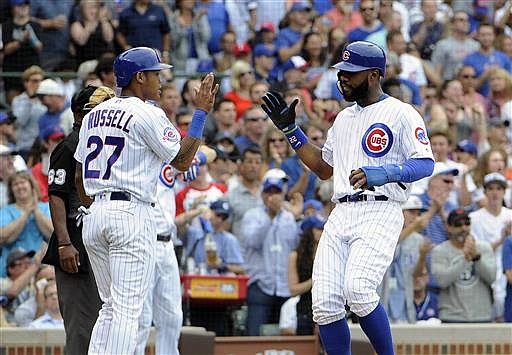 Chicago Cubs' Addison Russell (27) and Jason Heyward (22) celebrate after scoring against the Texas Rangers on a Chicago Cubs' Matt Szczur (20) two-RBI single during the sixth inning of an interleague baseball game, Friday, July 15, 2016, in Chicago.