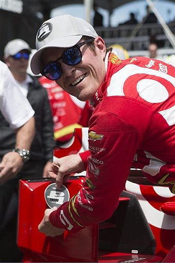 New Zealand's Scott Dixon places a decal on his car after winning the pole position during qualifying for the IndyCar auto race in Toronto on Saturday, July 16, 2016. (Chris Young/The Canadian Press via AP)