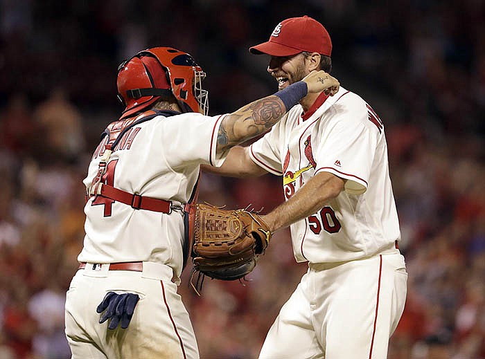 Cardinals starting pitcher Adam Wainwright gets a hug from catcher Yadier Molina after throwing a shutout Saturday night in a 5-0 win against the Marlins at Busch Stadium.