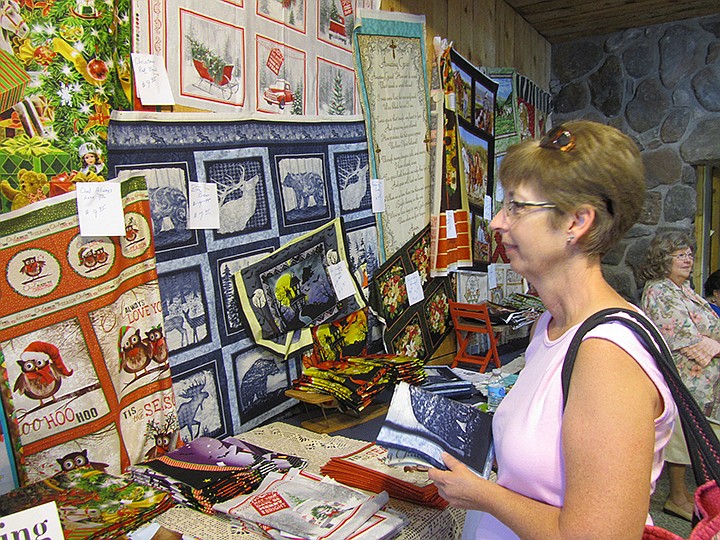 Linda Barnett of Jefferson City checks out the display of quilts by Stover Quality Quilting in Stover, Mo.