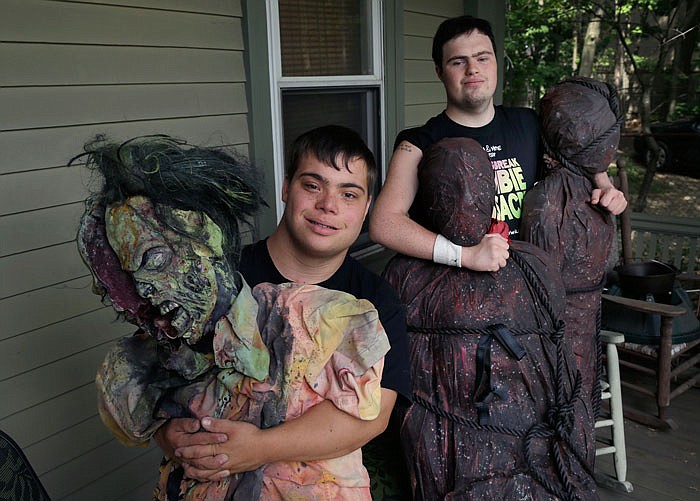 Mattie Zufelt, left, and Sam Suchmann pose with ghoulish figures at Sam's home. Suchmann and Zufelt, best friends with Down syndrome, are living their dreams of making a full-length, epic zombie movie and becoming celebrities. 