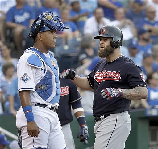 Cleveland Indians' Mike Napoli runs past Kansas City Royals catcher Salvador Perez to score after hitting a two-run home run during the first inning of a baseball game Tuesday, July 19, 2016, in Kansas City, Mo.