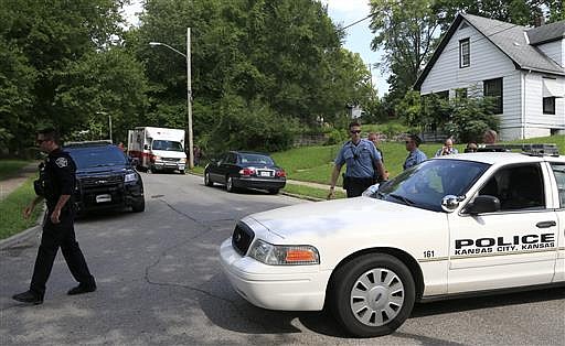 Kansas City, Kan., and Shawnee police officers work part of the shooting scene of a police officer in Kansas City, Kan., Tuesday, July 19, 2016. A suspect in a drive-by shooting fatally shot Capt. Robert Melton, a 17-year veteran of the Kansas City, Kan., Police Department, on Tuesday as the officer was sitting in his patrol car, police said.