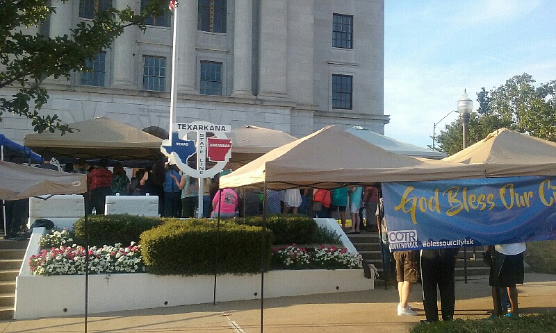 People gather at the Downtown Post Office on Wednesday, July 20, 2016 to pray for the city of Texarkana as the Church on the Rock's Praise and Worship team played music to encourage prayer, worship and peace within the city, especially public servants. 