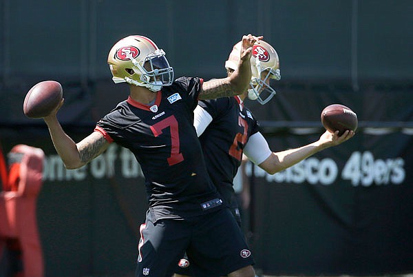 In this June 8 file photo, 49ers quarterback Colin Kaepernick (front) passes next to quarterback Blaine Gabbert during practice in Santa Clara, Calif. In 2012, Kaepernick was the answer in San Francisco. Now, he's fighting for a job he lost to Gabbert last season.