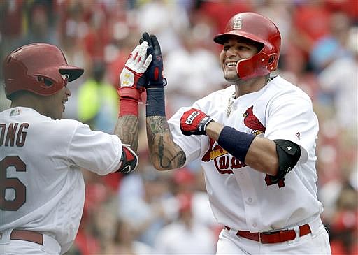 St. Louis Cardinals' Yadier Molina, right, is congratulated by teammate Kolten Wong after hitting a solo home run during the sixth inning in the first game of a baseball doubleheader against the San Diego Padres Wednesday, July 20, 2016, in St. Louis.